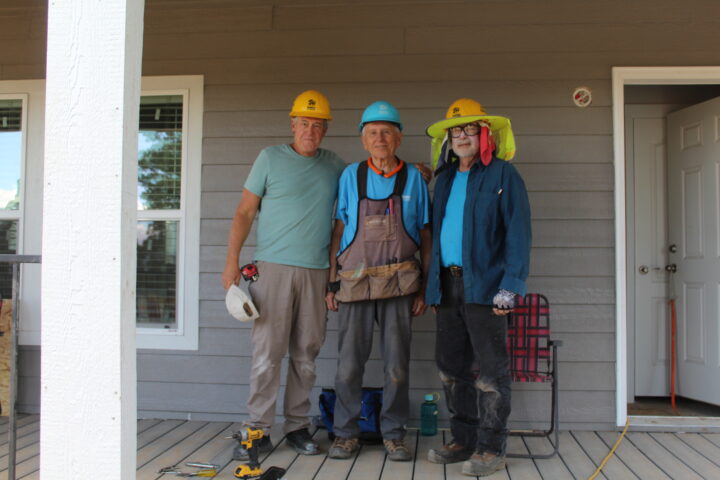 Three Habitat volunteers on a porch. 